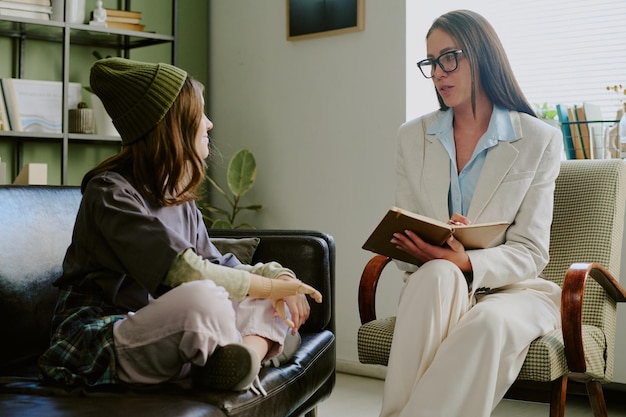 Photo therapist discussing with young patient in counseling session