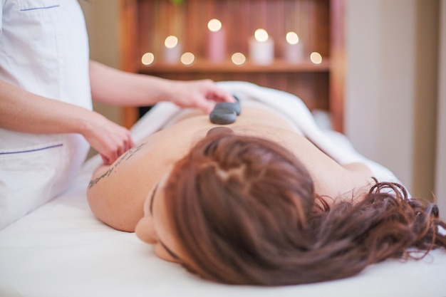 Therapist massaging with stones