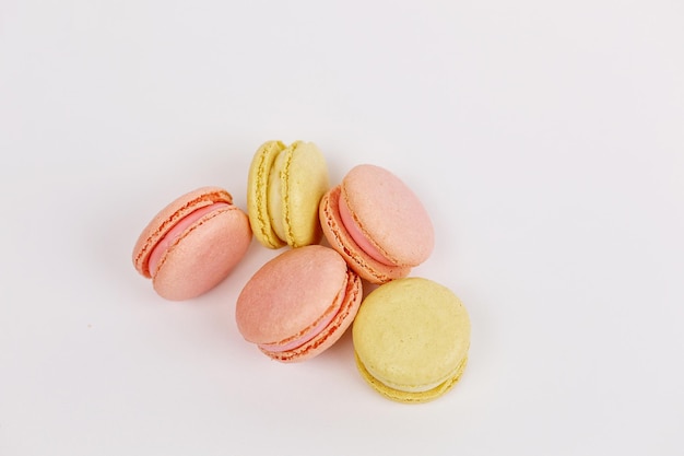 There are a lot of macaroons on a plain white background with a place for pastelcolored