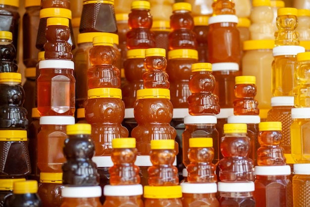 There are many jars of organic, natural honey on the counter for sale. Different honey,