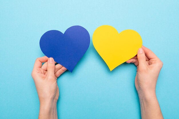 There is no war blue and yellow heart made of paper in female hands