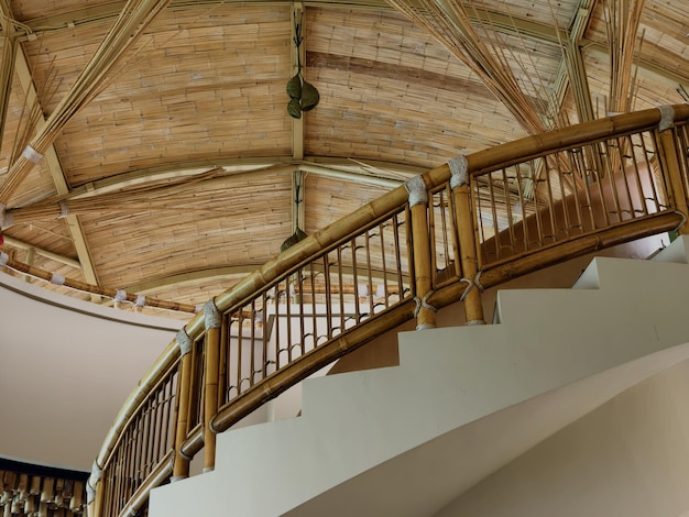 There is a spiral staircase in a building with a wooden railing