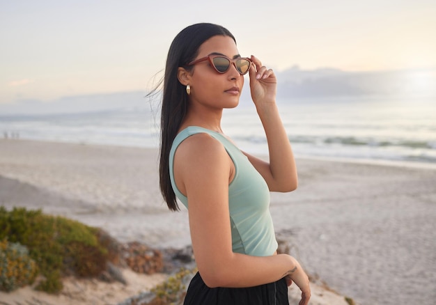 Theres a thunder in our hearts. Shot of a beautiful young woman enjoying some time at the beach.