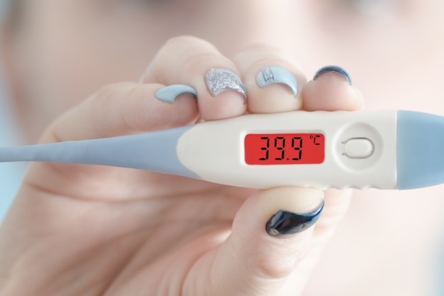 Thermometer in female hand. Hyperthermia