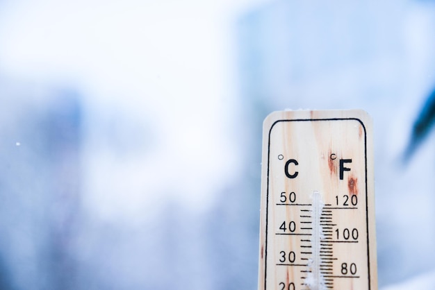 Thermometer on snow with low temperatures in celsius or fahrenheit in winter.