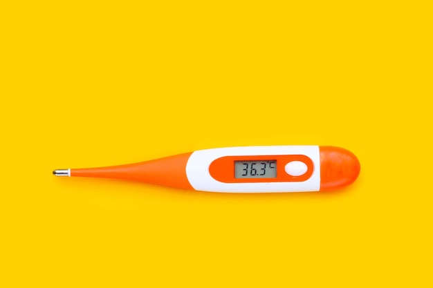 Thermometer on yellow background Top view