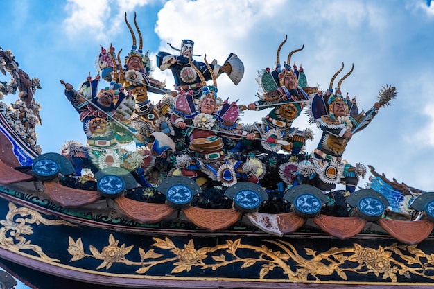 Photo these figurines are placed on top of an old chinese taoist temple as part