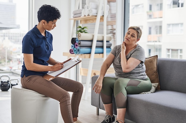 These pains are common and prominent to women your age Shot of a young physiotherapist consulting with a mature woman inside her office at a clinic