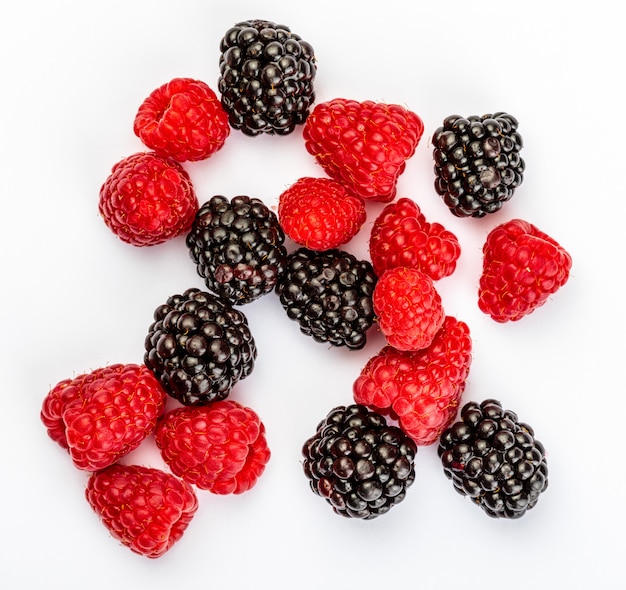 They look like artificial treats! But they are delicious and beautiful blackberries and fresh raspberries. Isolated