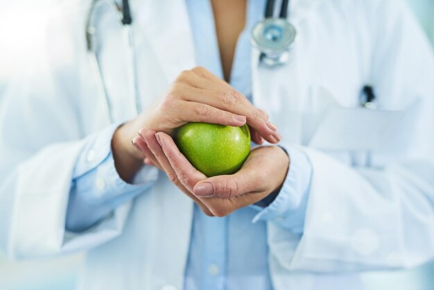 Theyre packed with powerful antioxidants Closeup shot of an unidentifiable doctor holding an apple