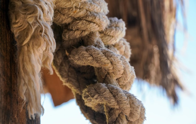 Thick natural fiber rope knot tied at beach hut, closeup detail