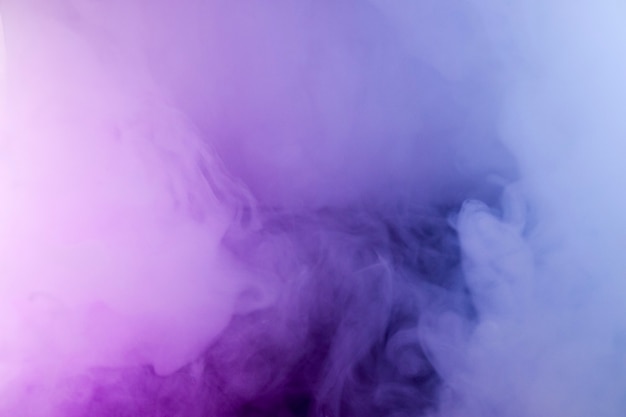 Thick smoke in the neon light. Pink and blue light, texture, background. Out of focus. Abstract dark background.