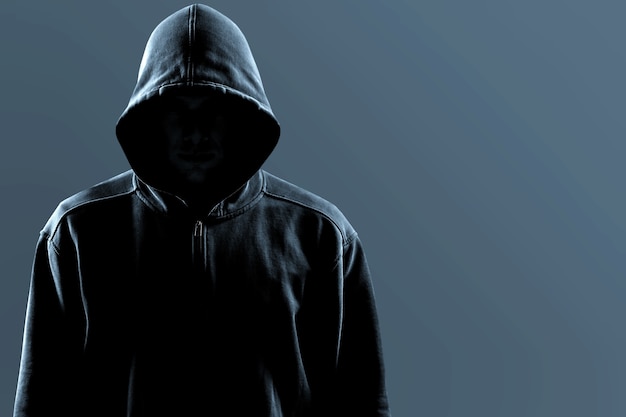 Thief in black clothes on grey background