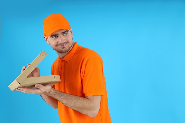 Thief delivery man with pizza on blue background