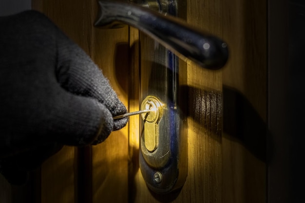 The thief tries to open the lock in the door with a special key