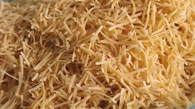 Thin dry vermicelli Wheat flour product containing gluten vitamins carbohydrates proteins and fats Small pasta closeup Fast food