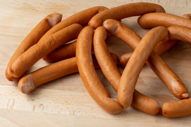 Thin long pork sausages on the wooden cutting board