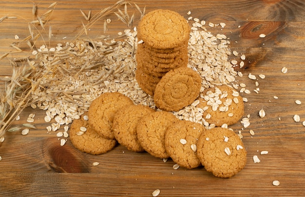 Thin oatmeal cookies or healthy cereal oat crackers closeup. Crispy anzac biscuit cookie with oat flakes on rustic table background