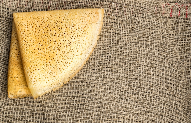 Thin Pancakes on a Burlap Background Top View