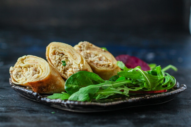 Thin pancakes chicken rolls with green salad