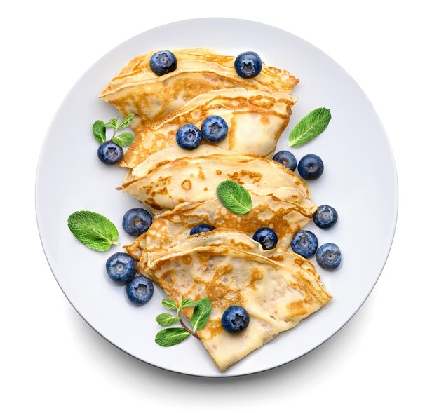 Thin pancakes or Crepes with fresh blueberries and mint leaves on a white background Top view