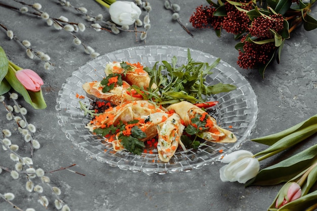 Thin pancakes with caviar and salmon rolled into rolls