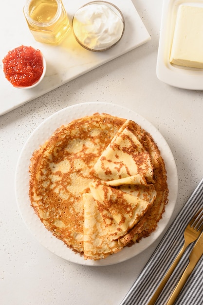 Thin pancakes with different tops honey sour cream red caviar Russian traditional breakfast