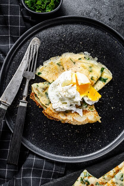 Thin pancakes with greens and poached egg