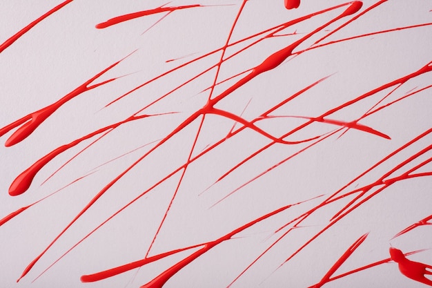 Thin red lines and splashes drawn on white background. Abstract art backdrop with brush decorative stroke. Acrylic painting with graphic stripe.