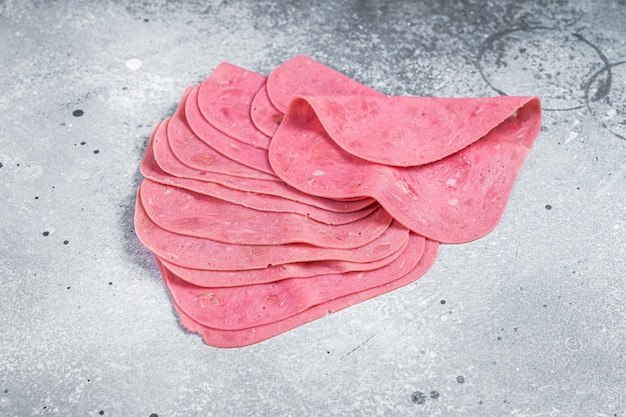 Thin slices of pork ham on a wooden kitchen table Gray background Top view