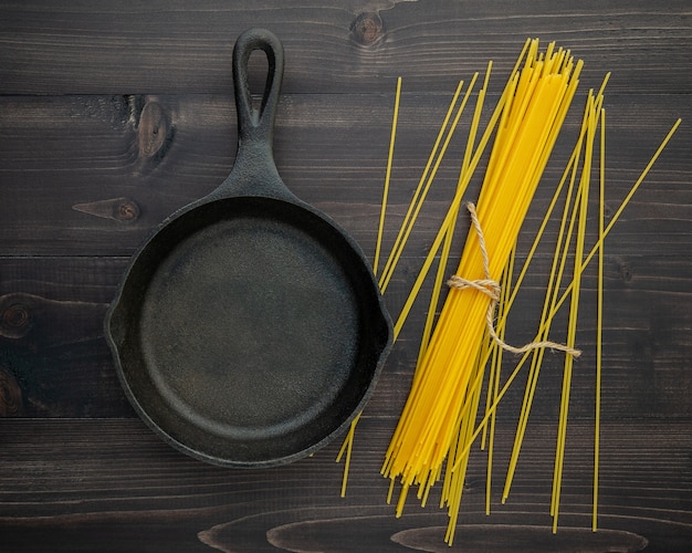 The thin spaghetti on black wooden background. 