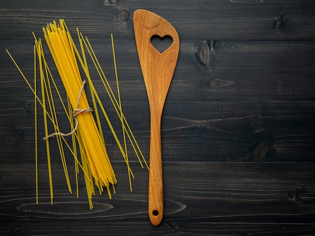 The thin spaghetti on black wooden background.