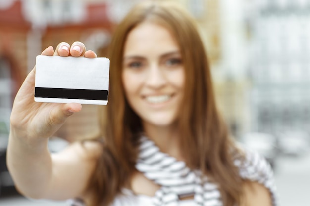 The thing you need for shopping Selective focus shot of a young smiling brunette shopper showing credit card