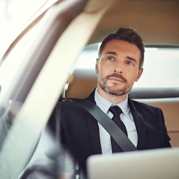 Thinking about the day ahead Cropped shot of a businessman in the backseat of a car