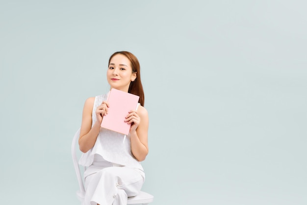 Thinking About Future Plans Pensive Asian Girl Sitting With Notepad