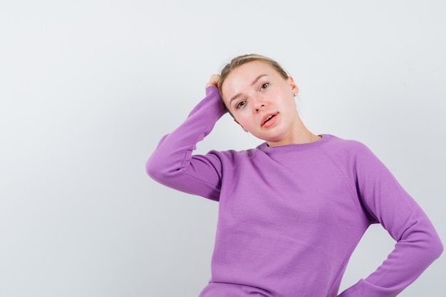 The thinking blonde woman is putting hand on head on white background