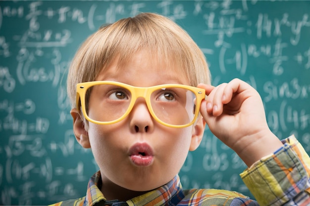 Thinking child with a blackboard in the background