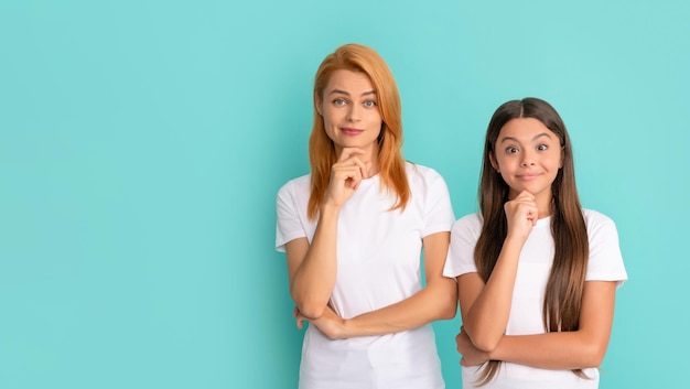 Thinking mother and kid with straight hair in white shirts decision