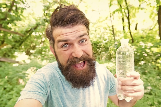 Thirst is everything Thirsty man Bearded man holding bottle of drinking water to quench his thirst Thirst or dehydration Thirst quenching