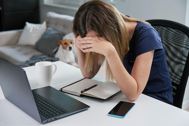 Thirty years old tired woman working late remotely at home office using computer remote work burnout