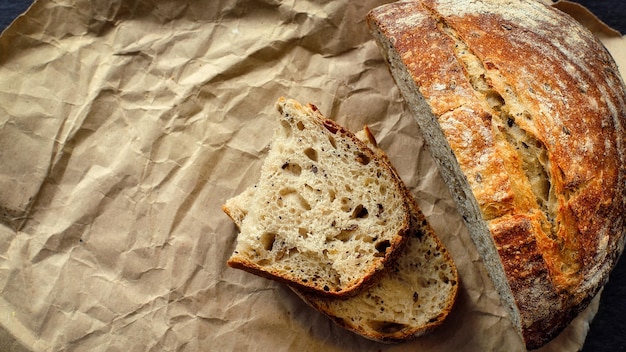 This is a loaf of fresh crusty bread with cereals on sourdough Yeastfree homemade cakes lie on yellow craft paper