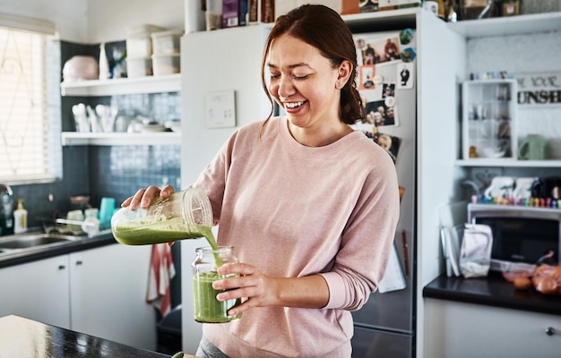 This will get me ready for the day Cropped shot of a young woman making a smoothie in the kitchen at home