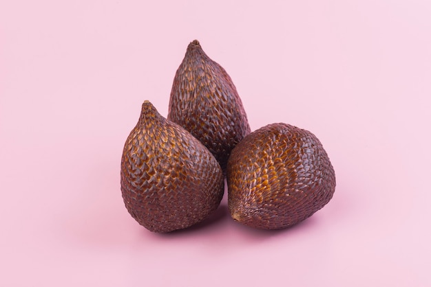 Thorny palm fruits or salak, Tropical fruit on pink