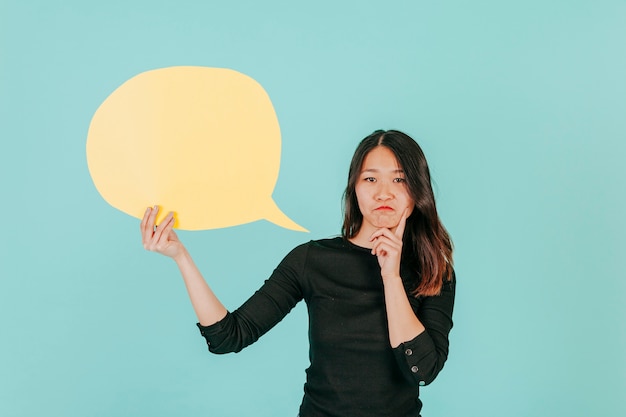 Thoughtful Asian woman with speech bubble