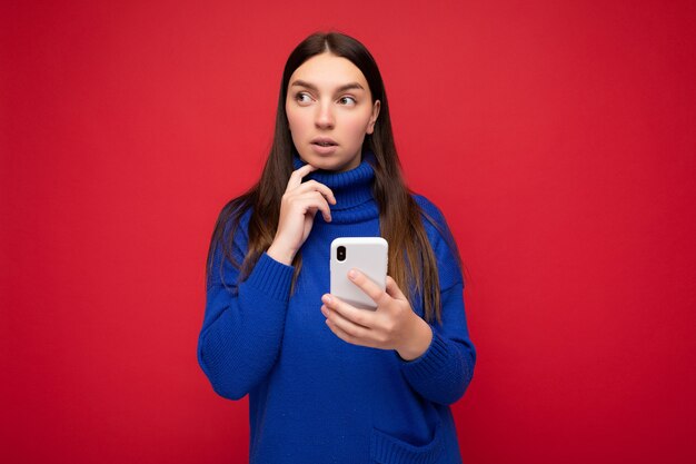 Thoughtful attractive positive good looking young brunette woman wearing stylish blue warm sweater