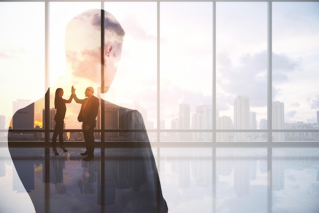 Thoughtful business man standing in abstract city interior with view sunlight and mock up place Brainstorm teamwork future and success concept Double exposure