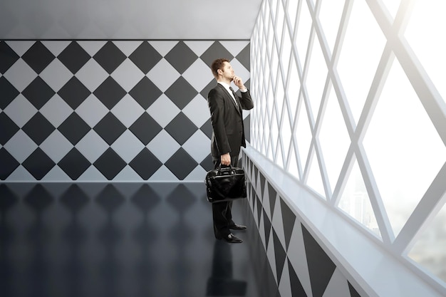 Thoughtful businessman in chessboard interior