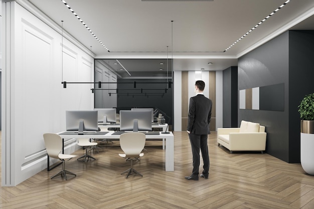 Thoughtful businessman standing in modern coworking office interior with furniture wooden flooring concrete walls equipment and daylight Workplace CEO and executive concept