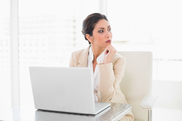 Thoughtful businesswoman working with a laptop