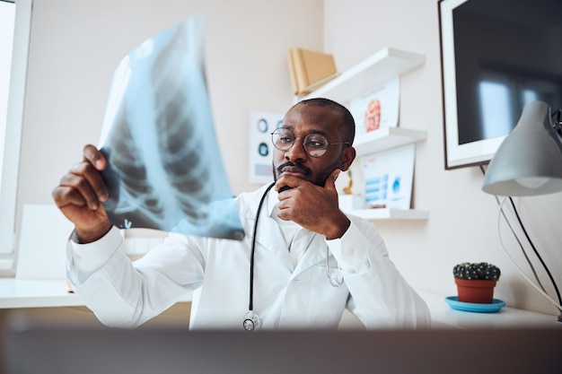 Thoughtful doctor is evaluating the chest radiograph